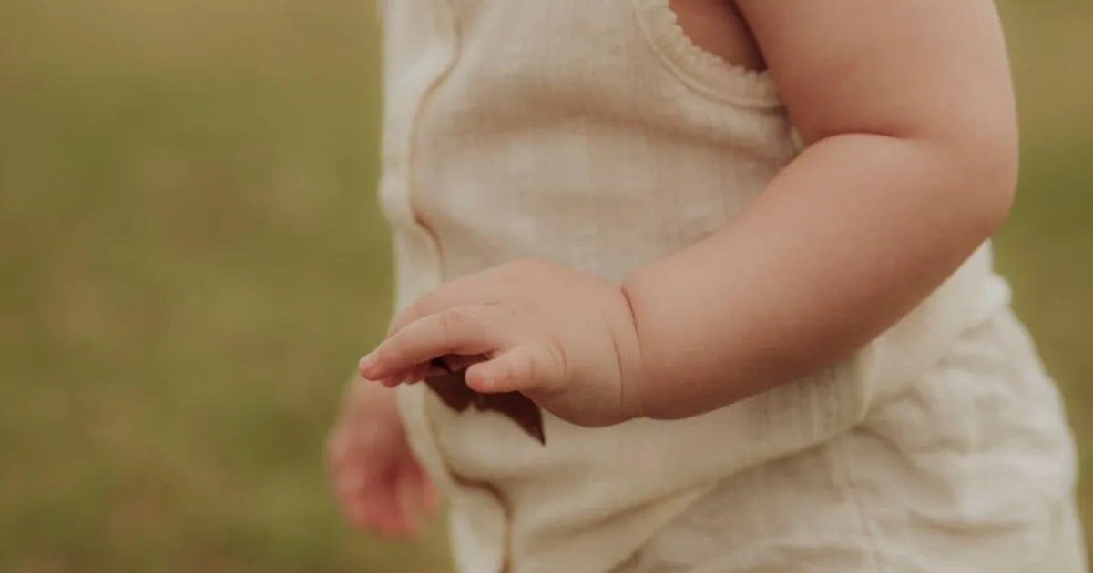 A close-up of a young child's bare arm outdoors