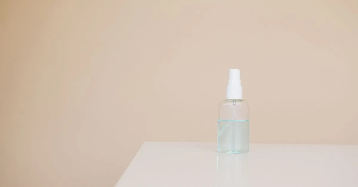 An unlabeled spray bottle standing on a white table
