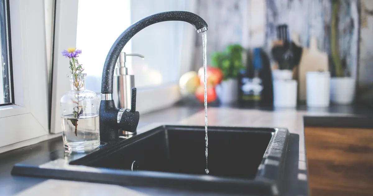 Water running from a kitchen tap into a sink